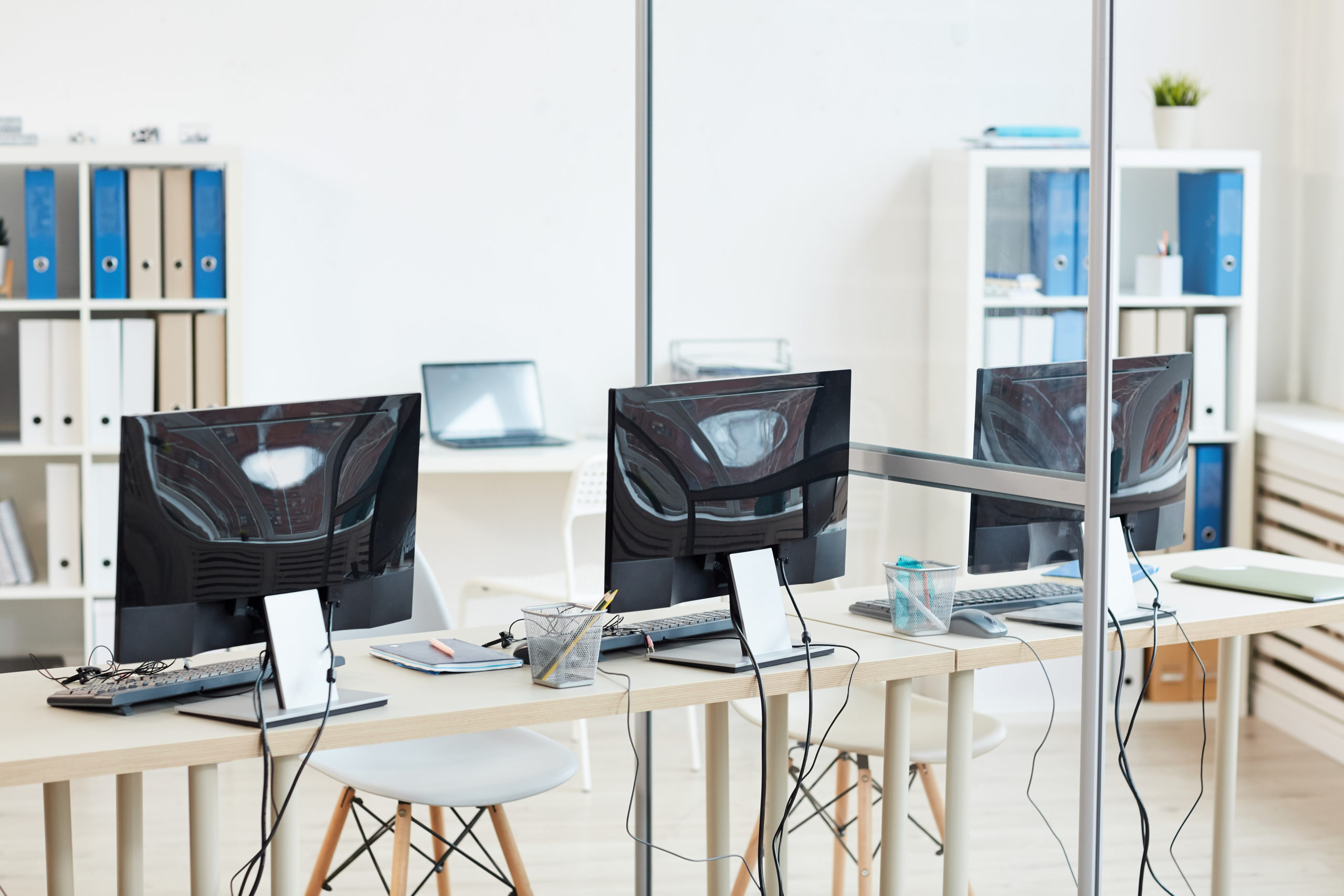 Background image of empty office interior with three computer desks in row, copy space