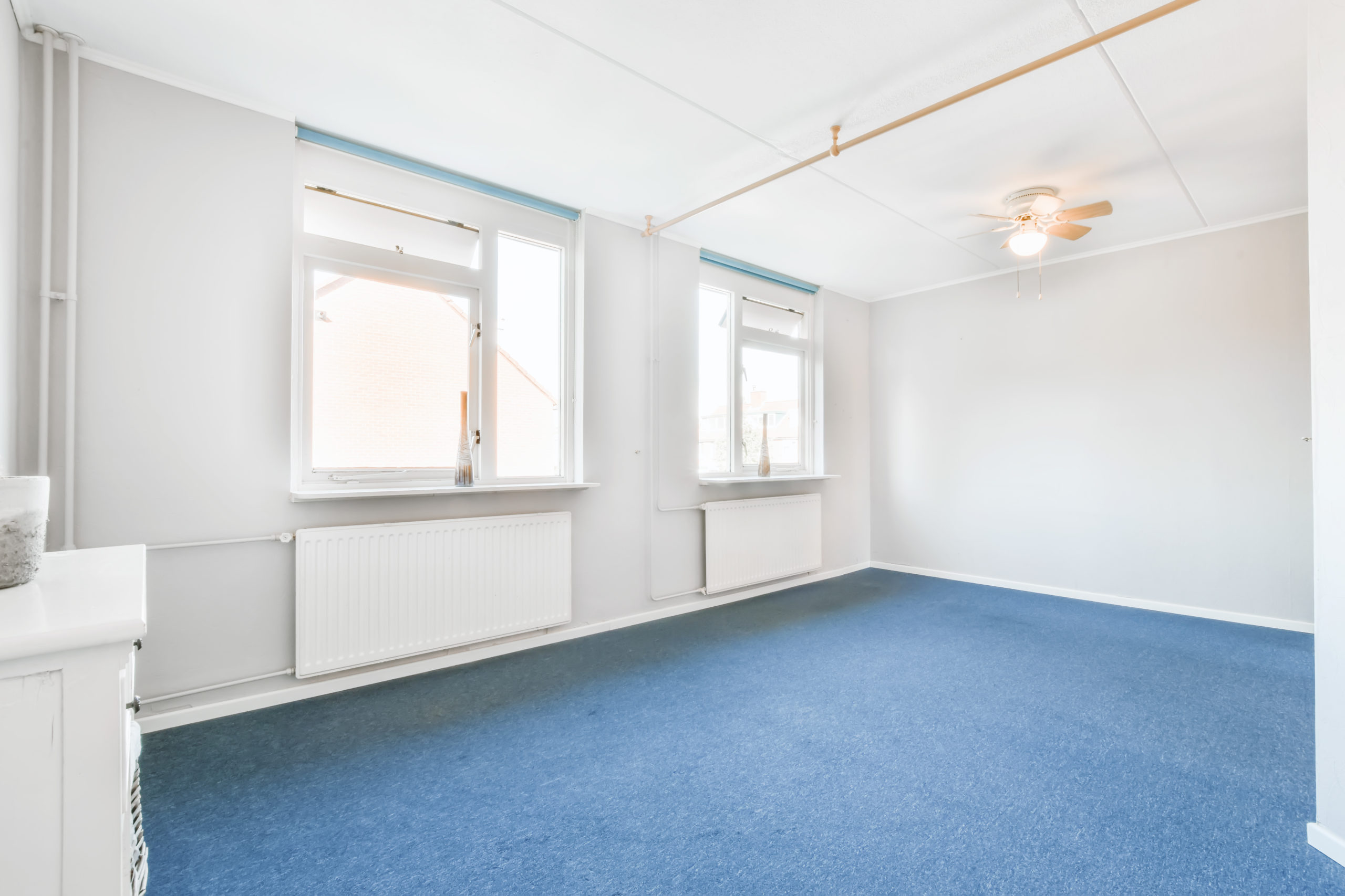 Interior of empty spacious room with two windows